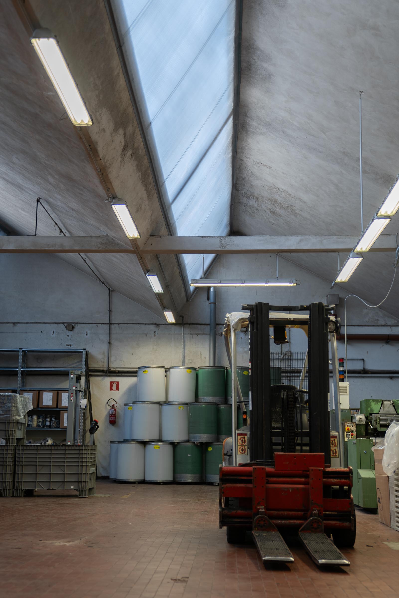 A wide shot of the ARA facility warehouse with forklift and empty wooltops storage barrels.