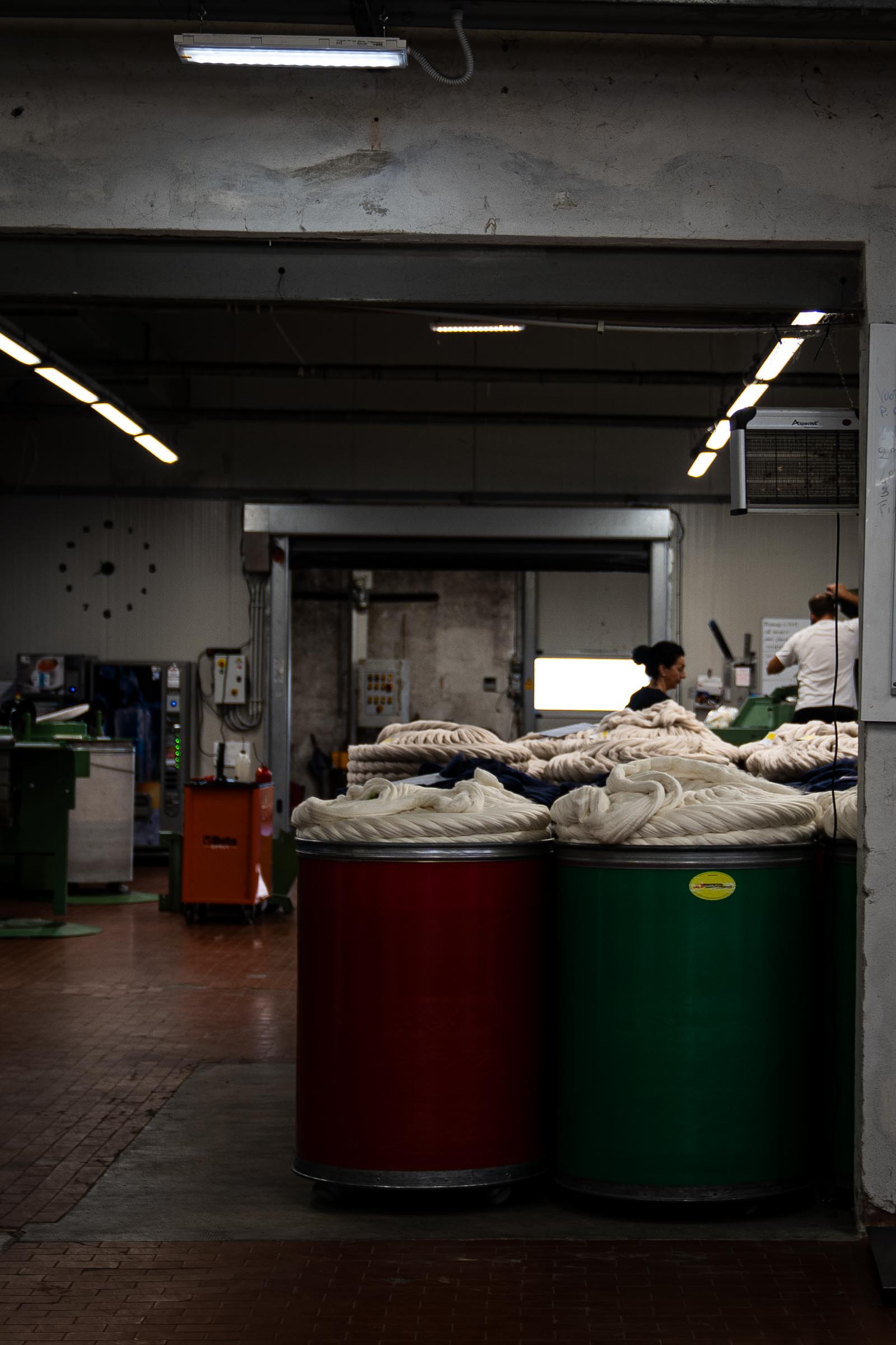 Wide shot of the ARA spinning facility with barrels of combed wool and cashmere tops resting.