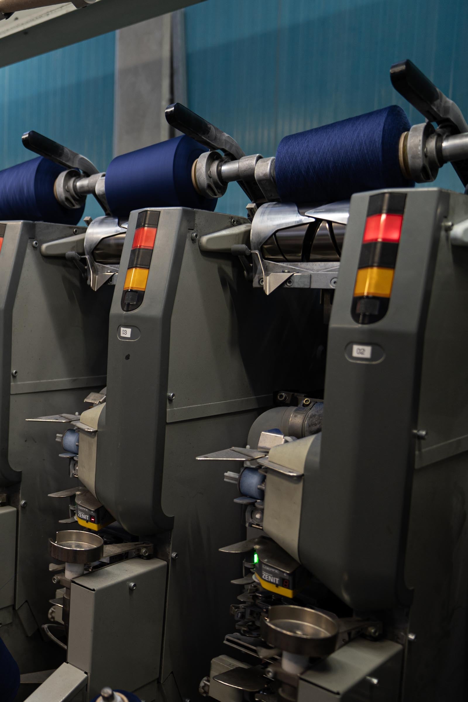 Navy-coloured wool tops being spun on a spinning machine.
