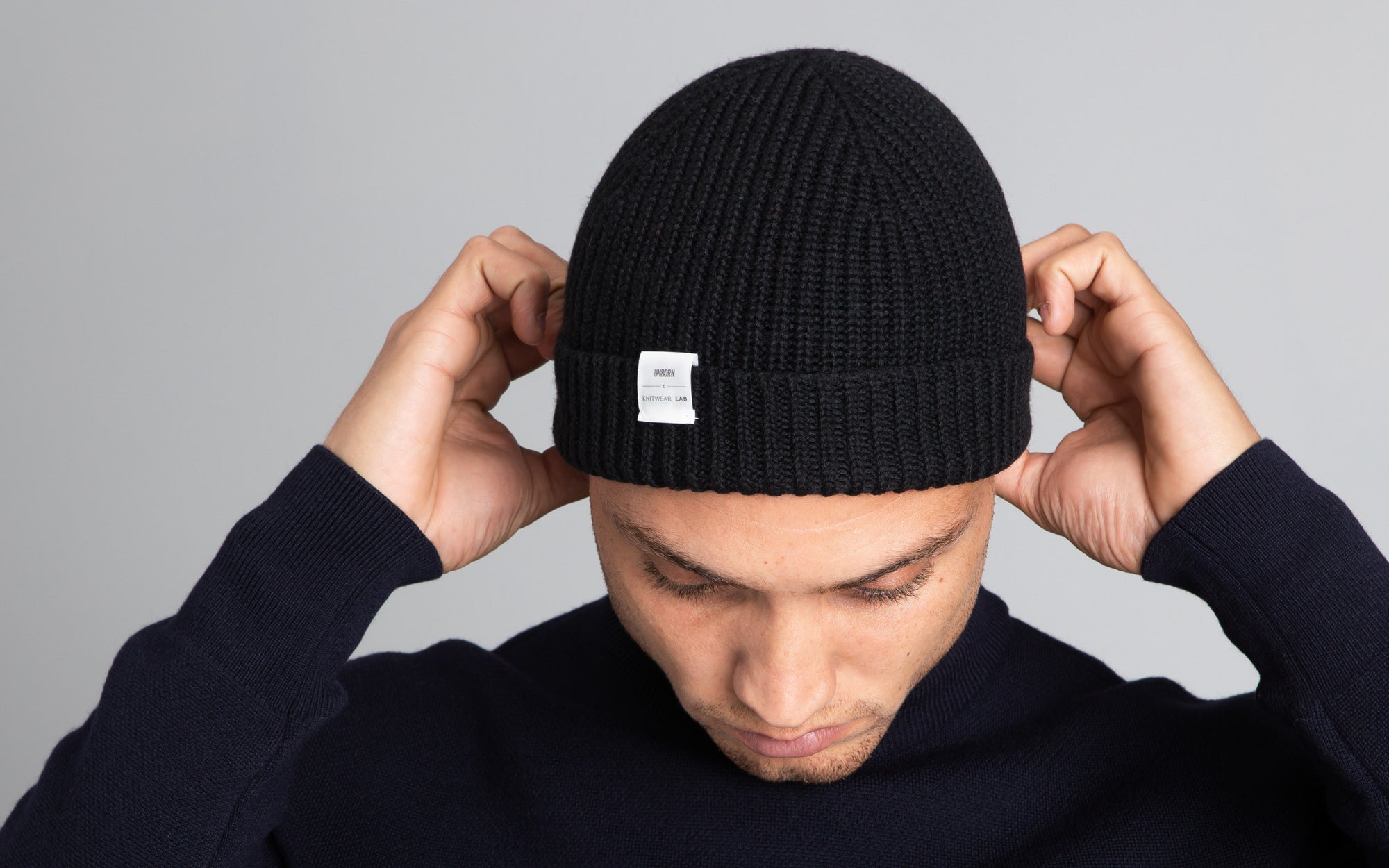 Front profile of model wearing The Merino Beanie in navy