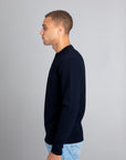 Model wearing The Merino Jacquard 2.0 Navy, left view - Unborn