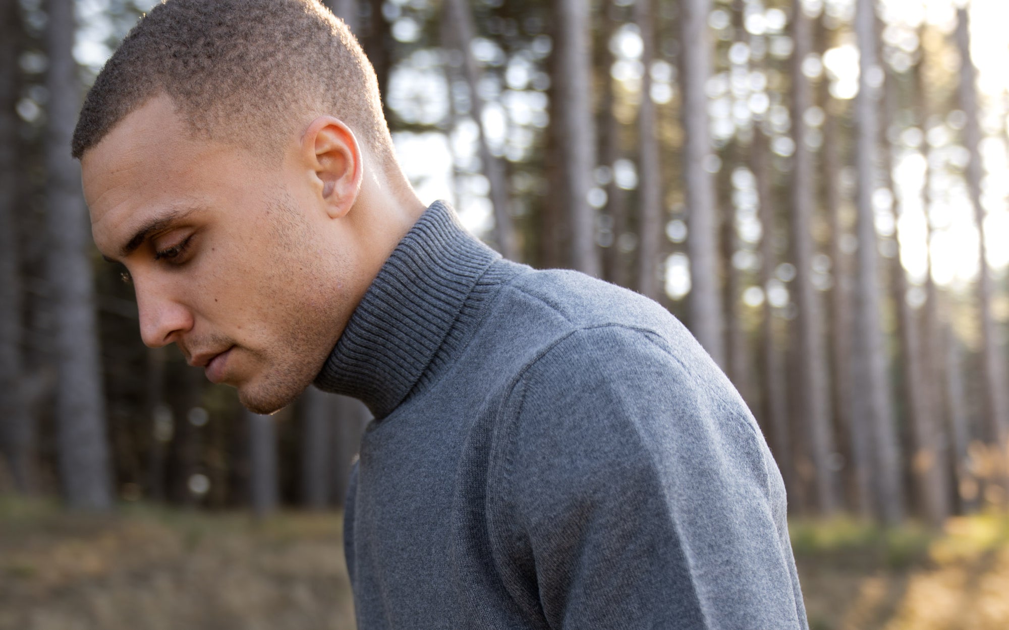 Close-up of model wearing of The Merino Roll Neck in Grey Melange in outdoor scenery
