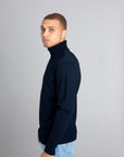 Model wearing The Merino Roll Neck Sweater Navy, left view - Unborn