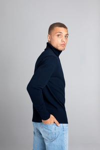 Model wearing The Merino Roll Neck Sweater Navy, right view - Unborn