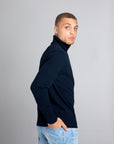 Model wearing The Merino Roll Neck Sweater Navy, right view - Unborn
