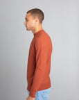 Model wearing The Merino Sweater lightweight Burnt Orange, left view - Unborn