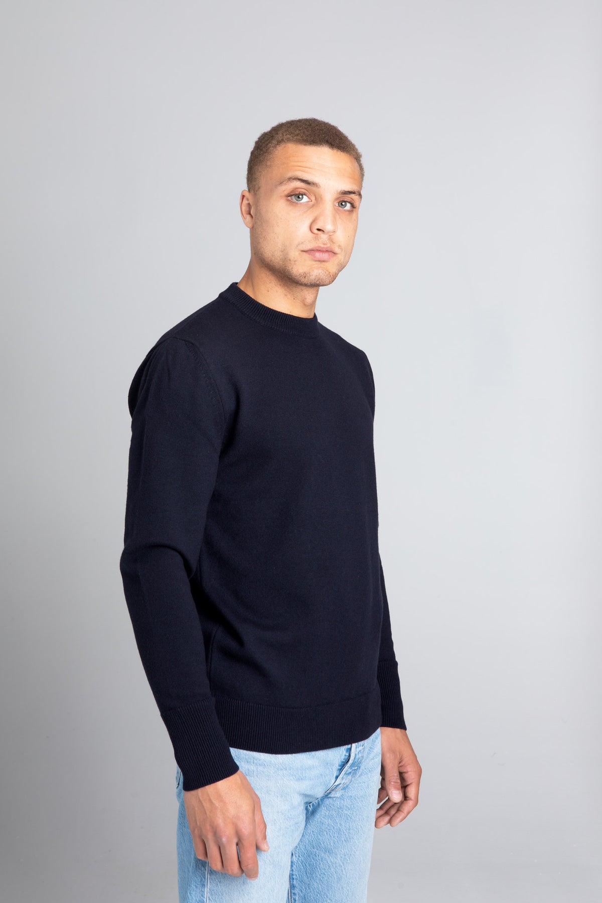 Model wearing The Merino sweater Navy, right view - Unborn