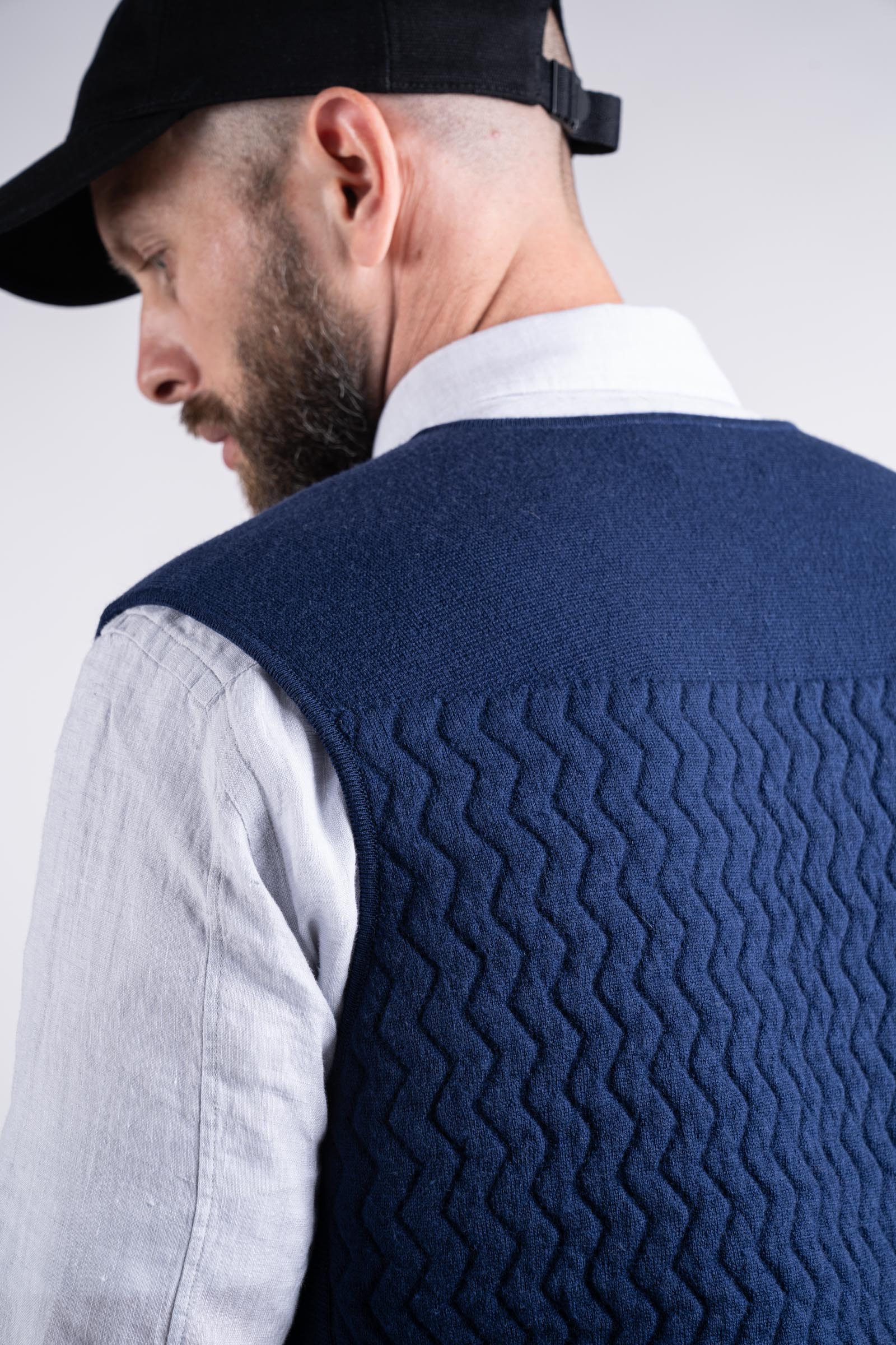 Details of back textures while model wearing the UNBORN Merino d&#39;Arles Padded vest in medieval blue