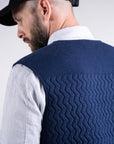 Details of back textures while model wearing the UNBORN Merino d'Arles Padded vest in medieval blue