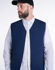 Front view of model wearing the UNBORN Merino d'Arles Padded vest in medieval blue with open zipper