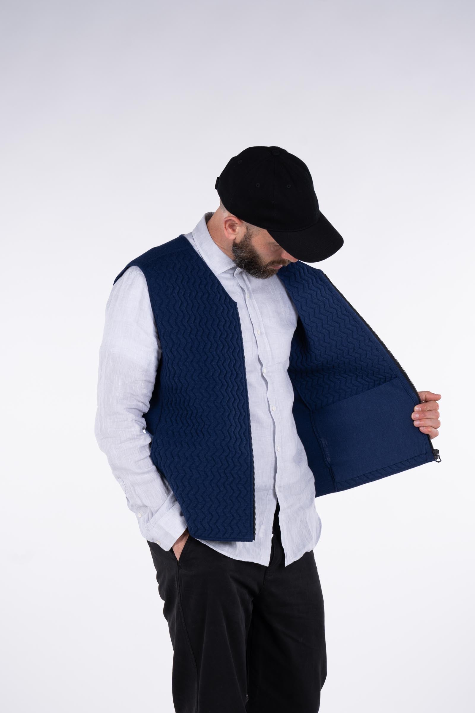Front view of model wearing the UNBORN Merino d&#39;Arles Padded vest in medieval blue showing pocket
