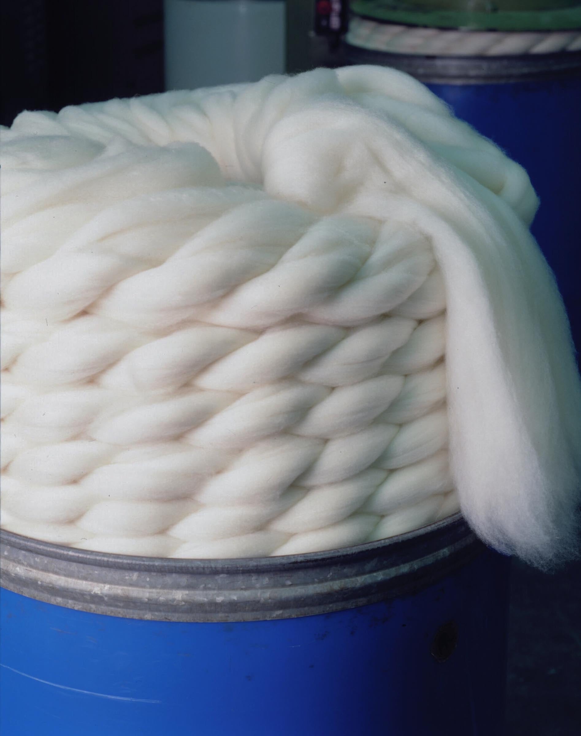 Fresh combed wool tops resting on top in a barrel at pettinature di verrone