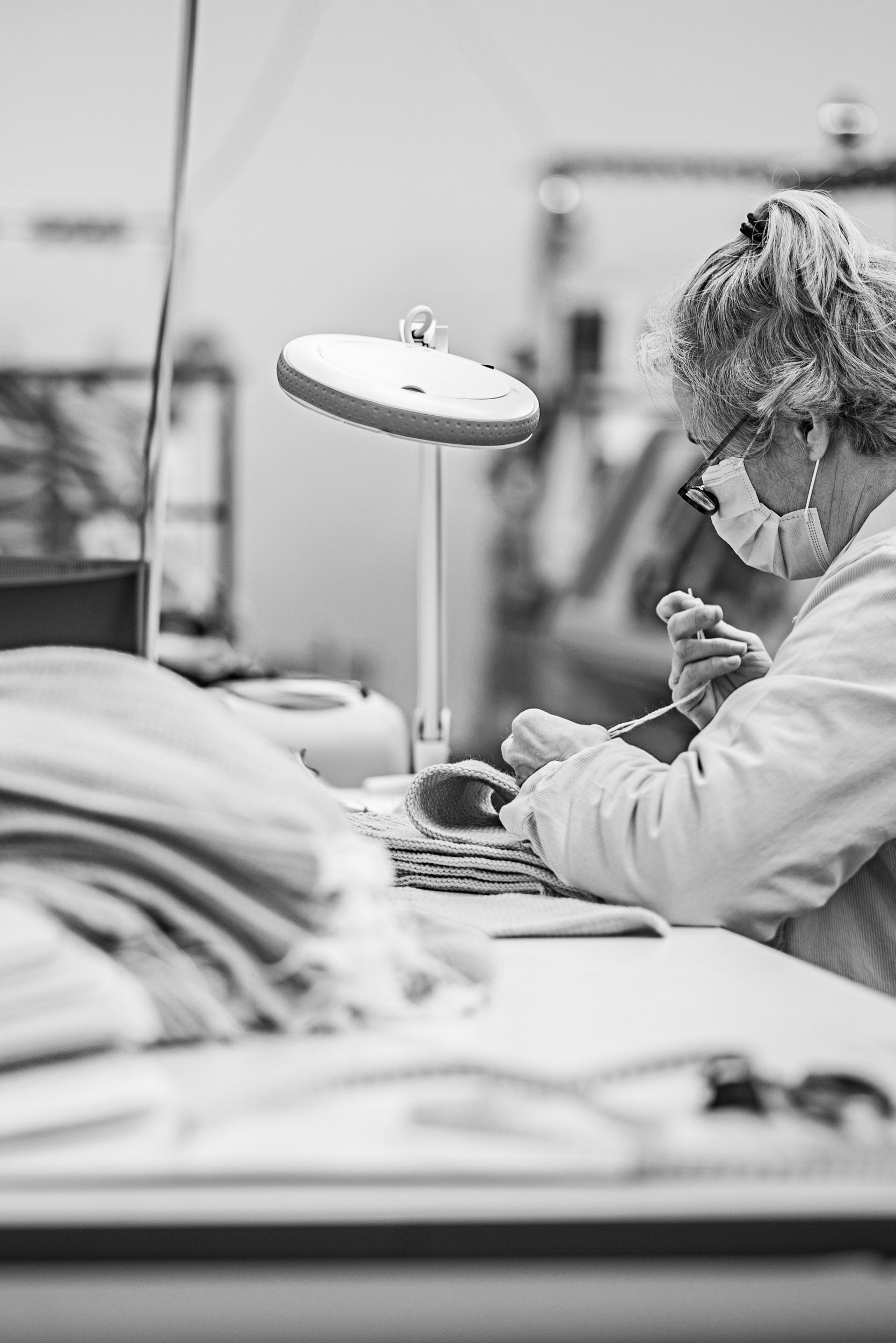 Seamsters sewing on garment labels to Merino knitwear at Point Tricot