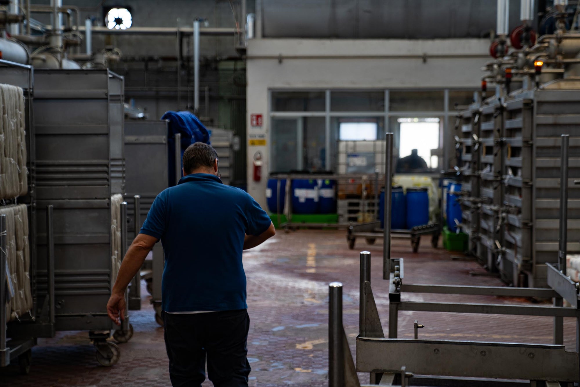 Industrial worker walking through the industrial hals of the Tintoria Ferraris dyeing facility