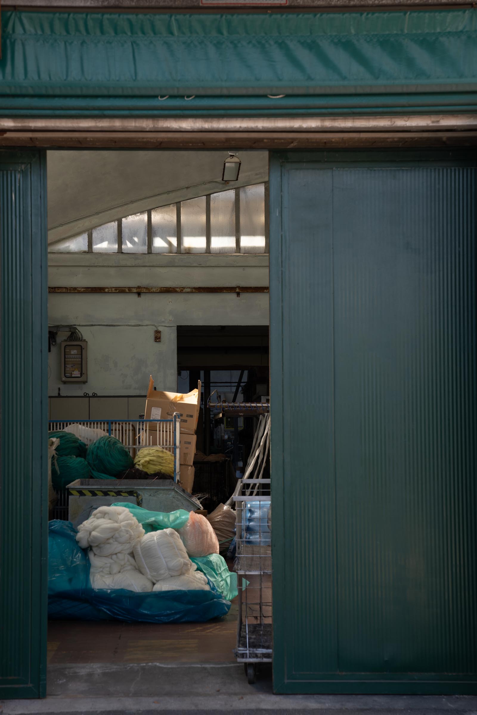 A look-through shot into the dyeing facility of Tintoria Ferraris with Merino Wool bumps in storage.