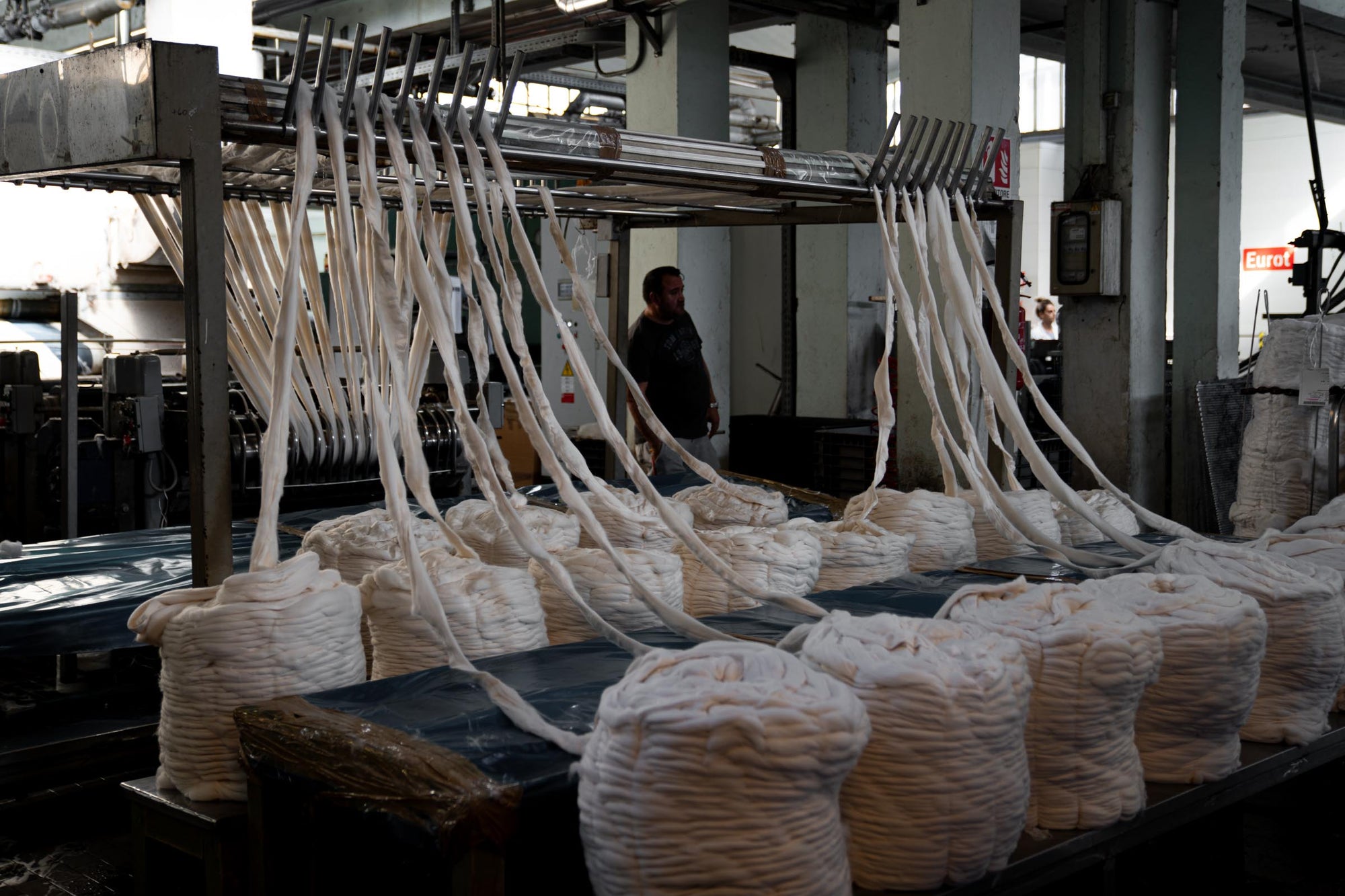 Undyed Merino wool bumps being fed into the wool coming and blending machine