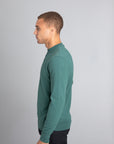 Model wearing The Merino Wool Sweater Light Foggy Green , left - Unborn