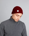 Model wearing The Merino wool beanie brick red, front view Unborn
