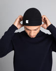Model wearing The Merino wool beanie Dark Navy, front view Unborn