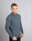 Model wearing The Merino Wool Sweater Olive Green, front - Unborn