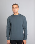 Model wearing The Merino Wool Sweater Olive Green, front - Unborn