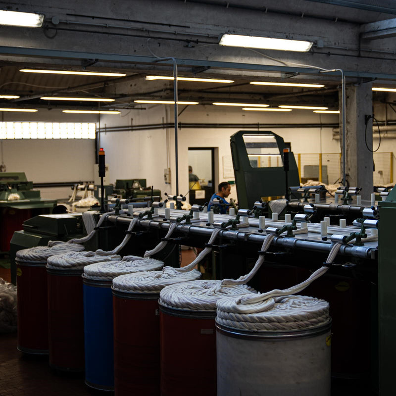 A wide shot of Merino wool tops being fed into the wool blending and combing machine at the ARA spinning facility.