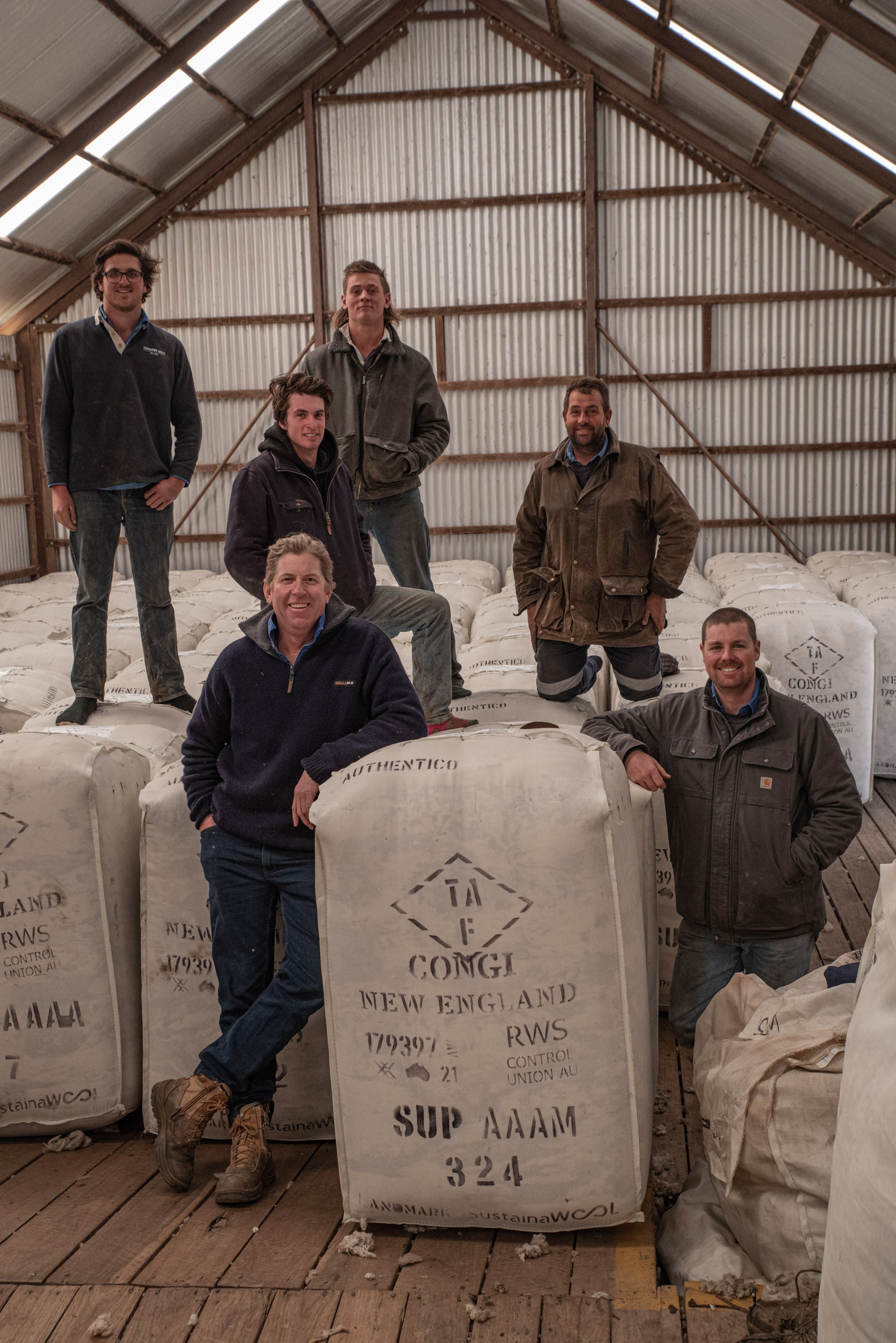 The Congi team of shepherds posing a packed bales of Merino wool