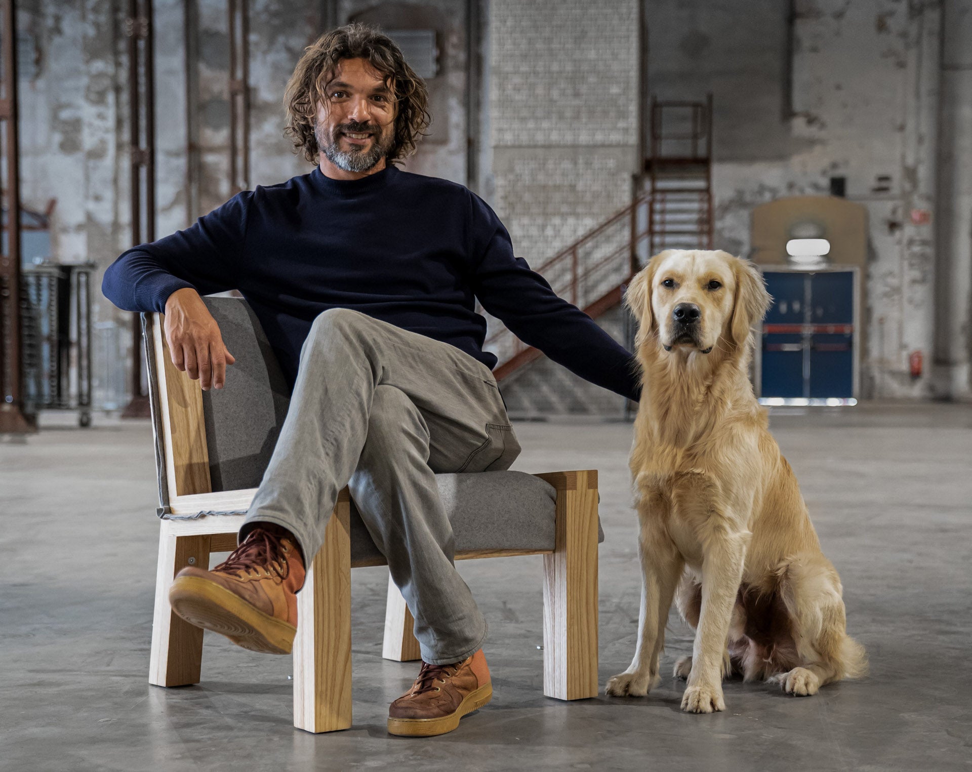 Melle Koot sitting on the Herbarium Lounge chair with his Labrador sitting on the side