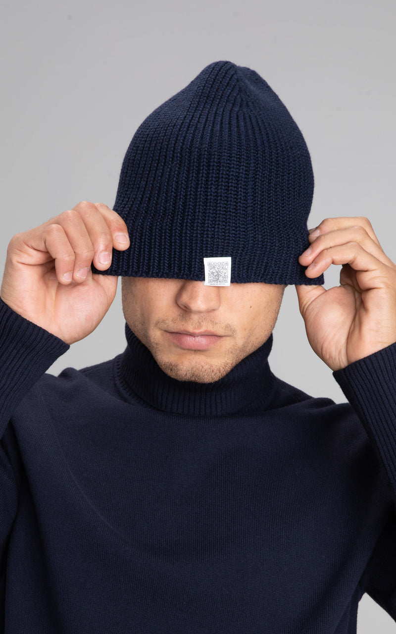 Model pulling down the edge o The Merino Beanie exposing the QR code 