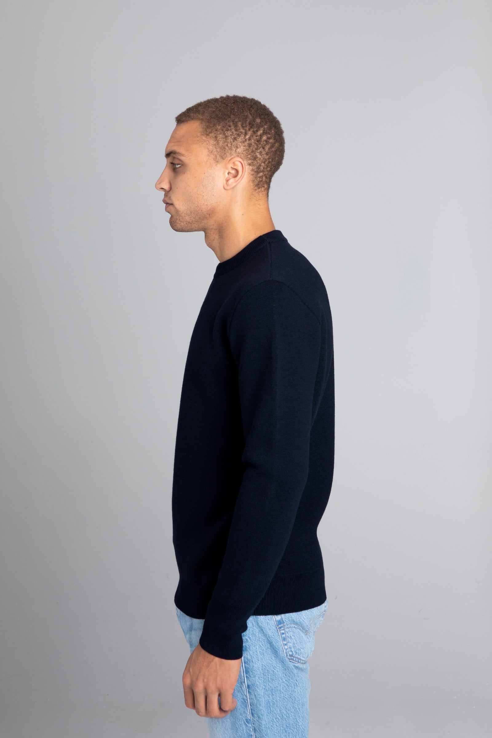 Model wearing The Merino Jacquard 2.0 Navy, left view - Unborn