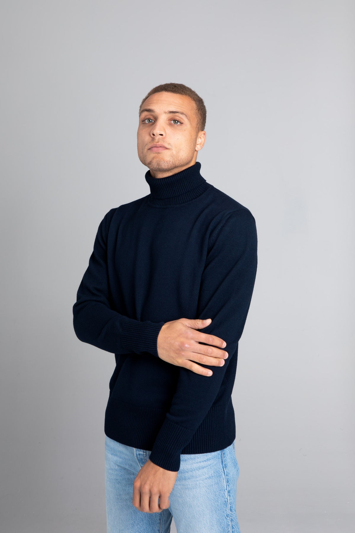 Model wearing The Merino Roll Neck Sweater Navy, front view - Unborn