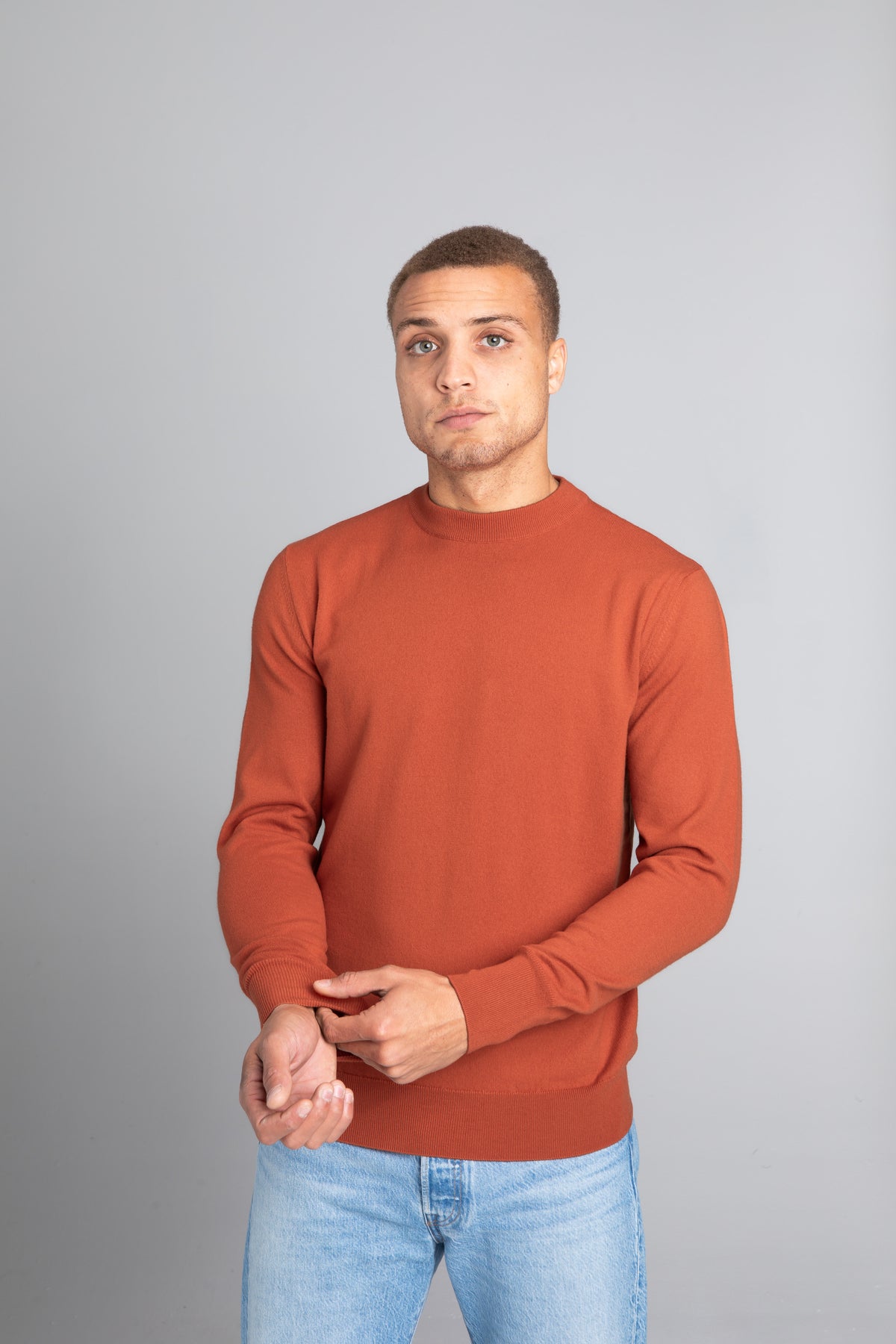 Model wearing The Merino Sweater lightweight Burnt Orange, front view - Unborn