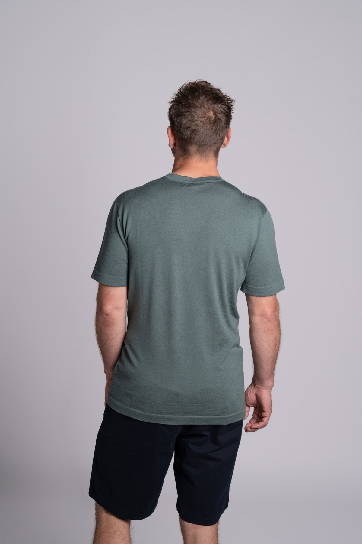 Model wearing Merino Featherweight T-shirt Moss Green Back