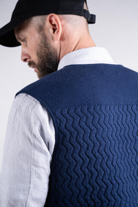Details of back textures while model wearing the UNBORN Merino d'Arles Padded vest in medieval blue