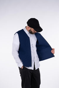 Front view of model wearing the UNBORN Merino d'Arles Padded vest in medieval blue showing pocket