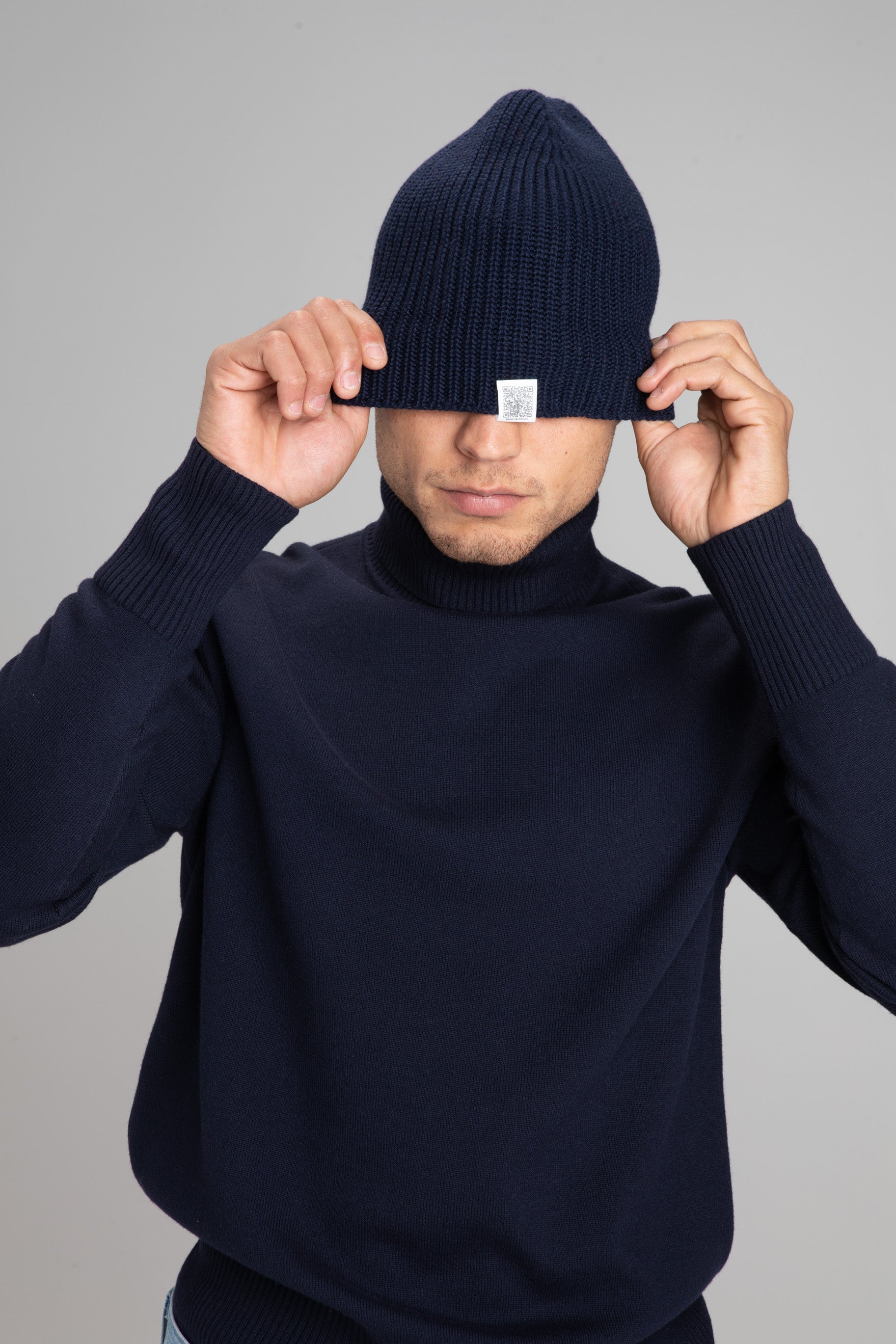 Model Wearing Light Merino Roll Neck Navy Pulling Beanie Navy Over eyes 