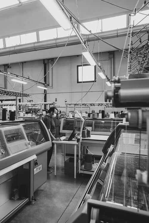 Knitwear enigineer operating knitting machines at Point Tricot