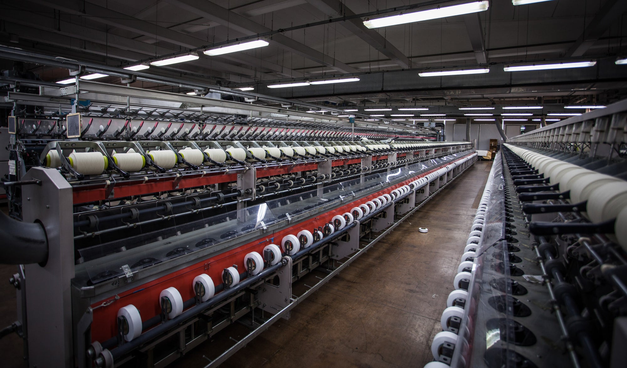 Line of yarn coning machines at spinning facility in Tarcento