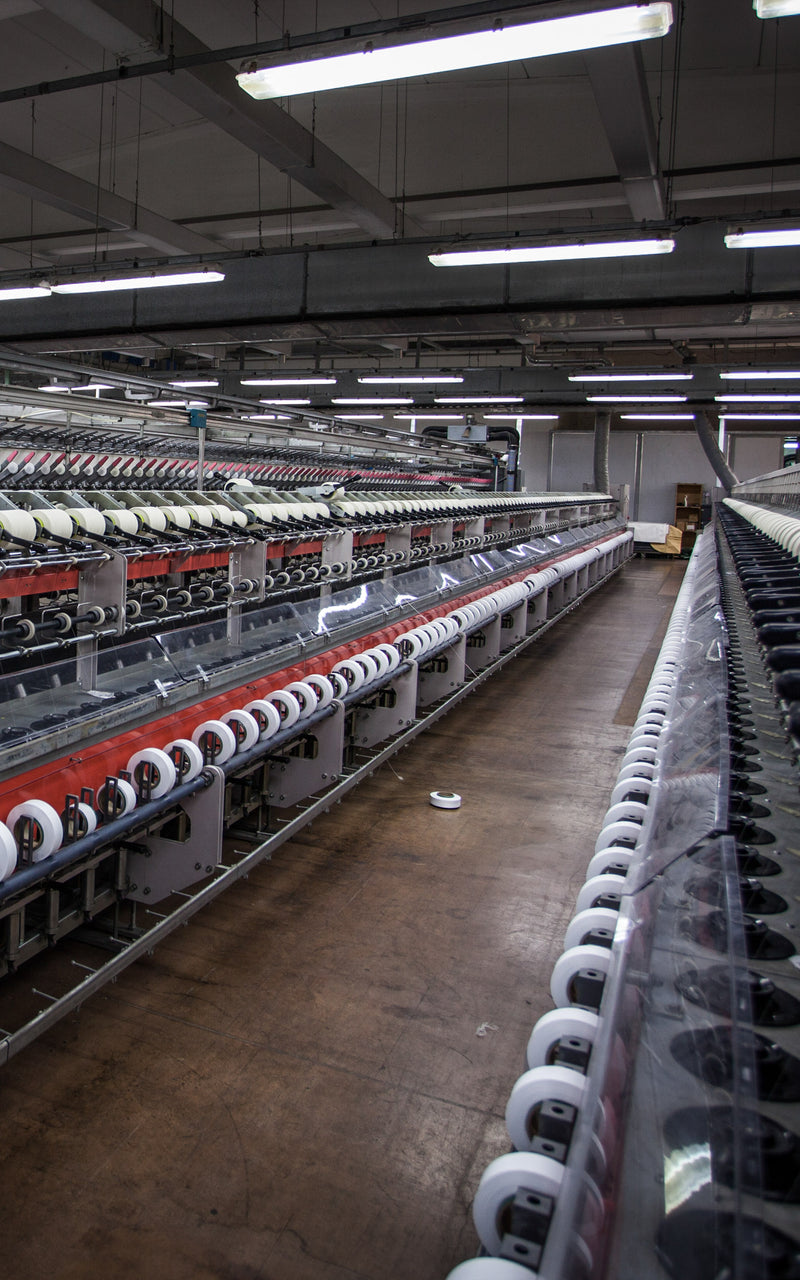 Line of yarn coning machines at spinning facility in Tarcento