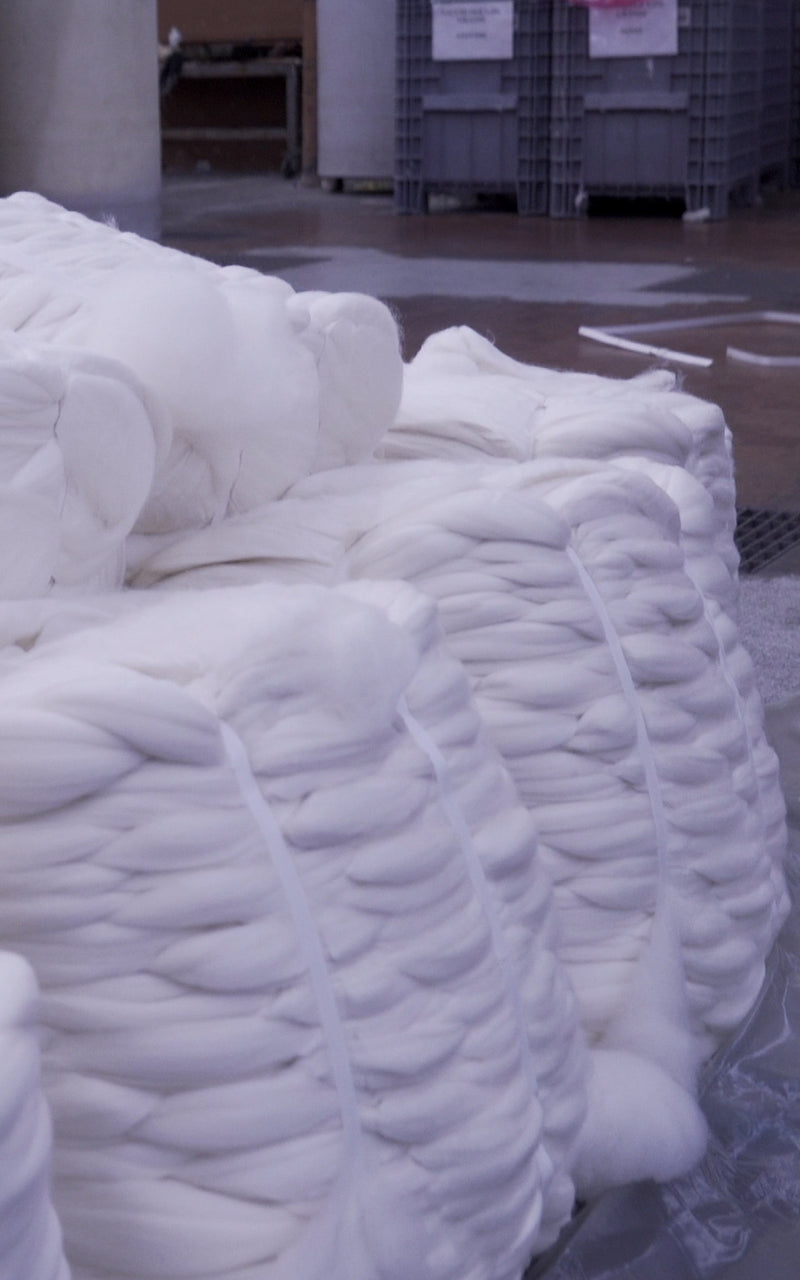 Combed Merino wool bump tops stacked in wharehouse