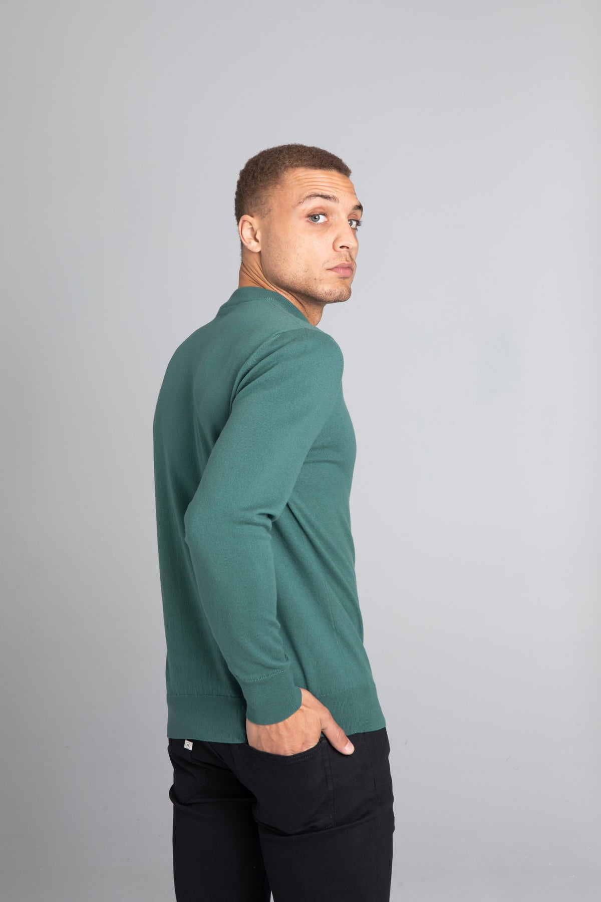 Model wearing The Merino Wool Sweater Light Foggy Green , back - Unborn