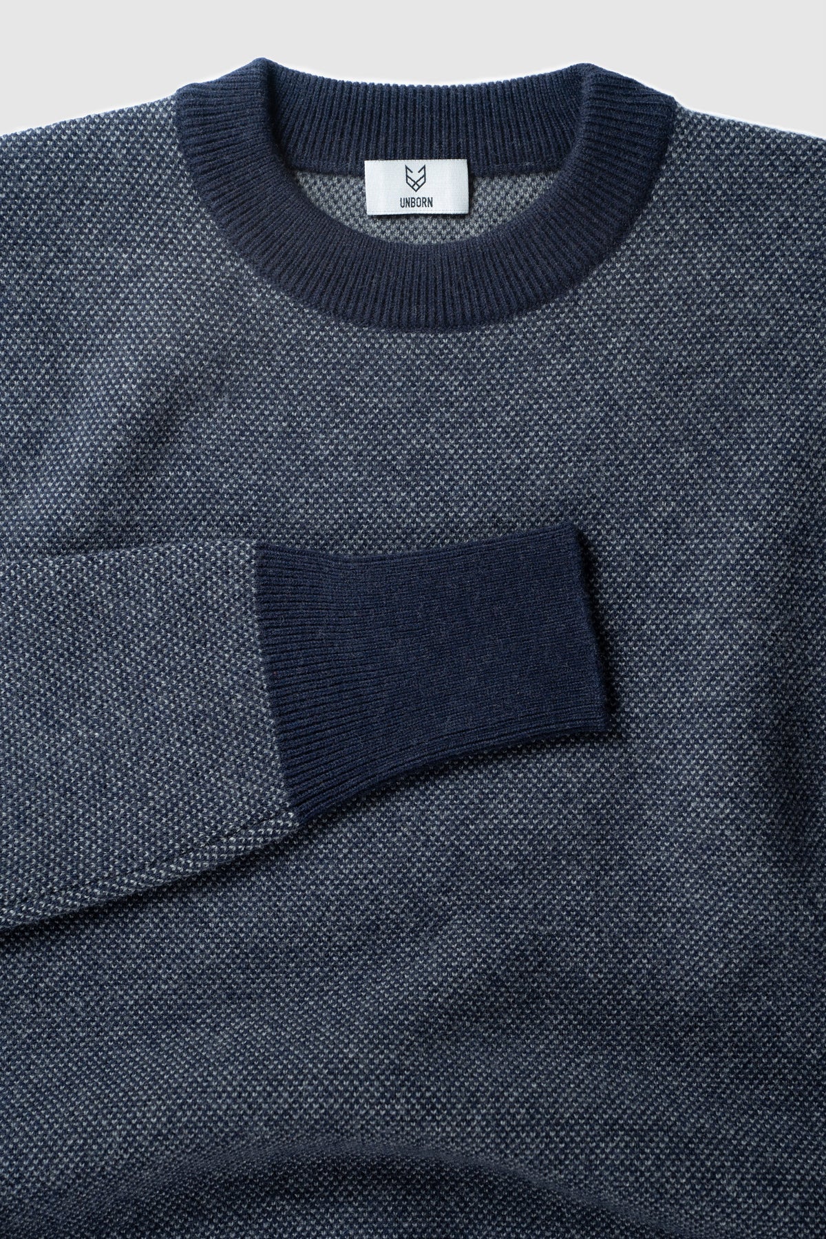 The Merino wool jaquard sweater Navy Grey, close up flat front - Unborn