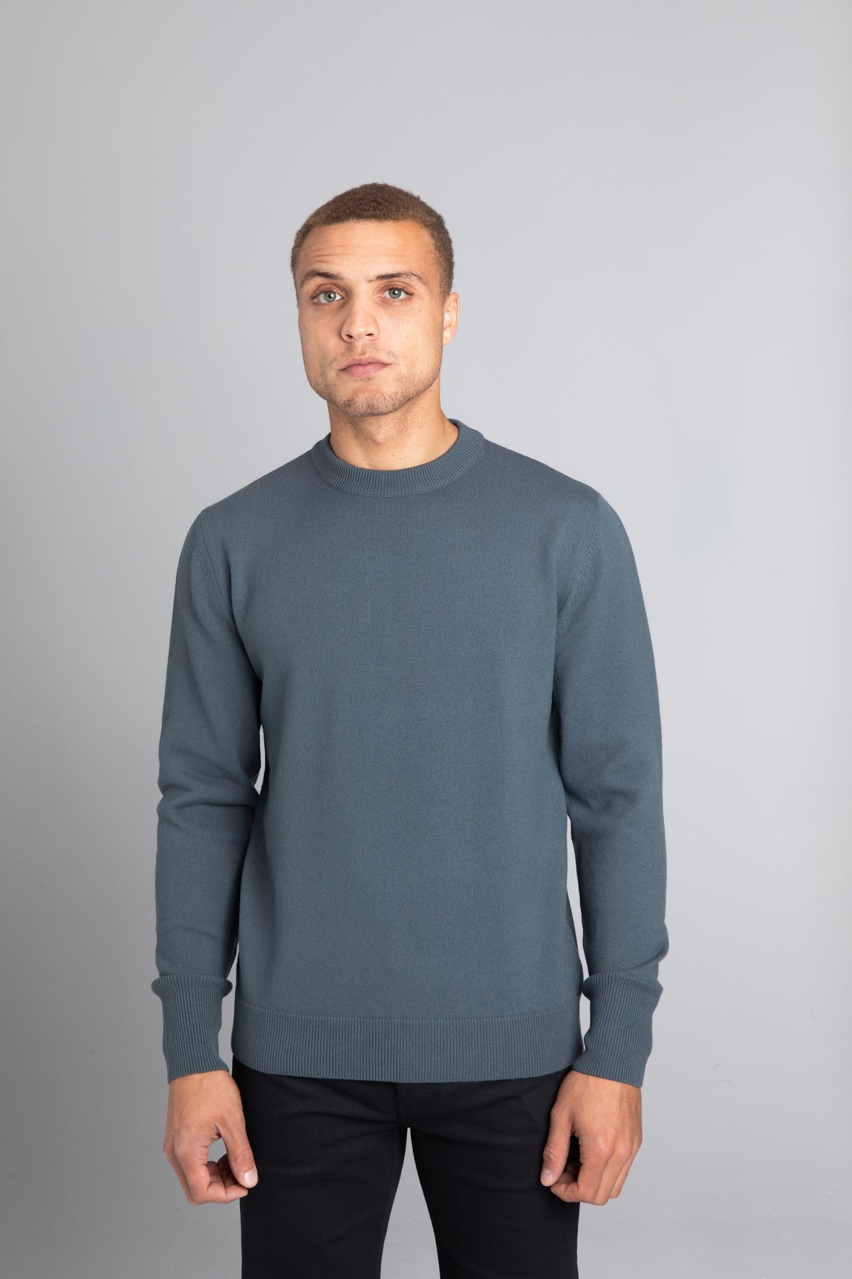 Model wearing The Merino Wool Sweater Olive Green, front - Unborn