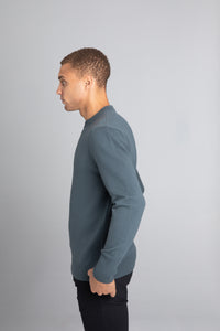 Model wearing The Merino Wool Sweater Olive Green, left - Unborn